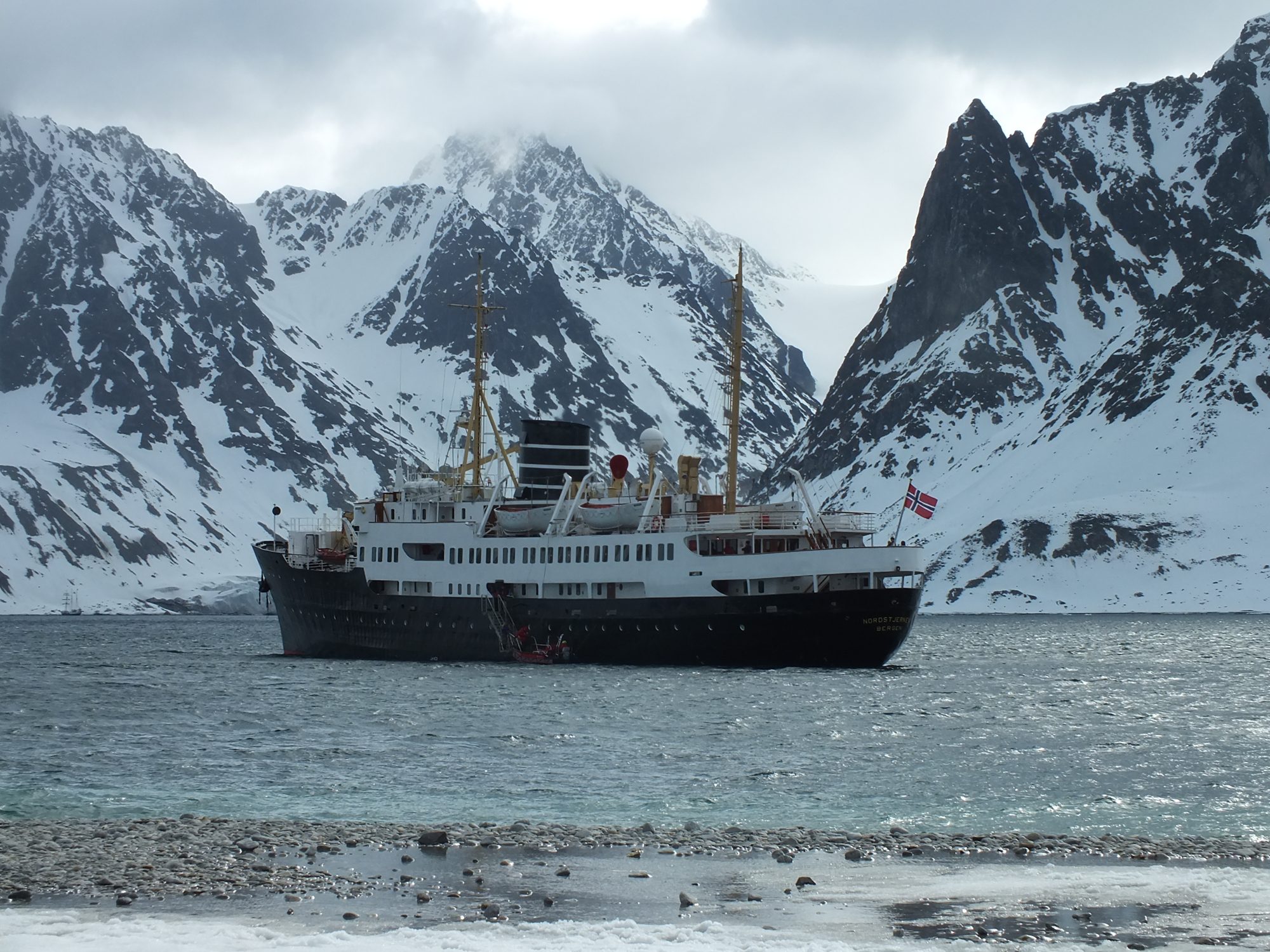 Norwegian fjord with the vessel at a village quay
